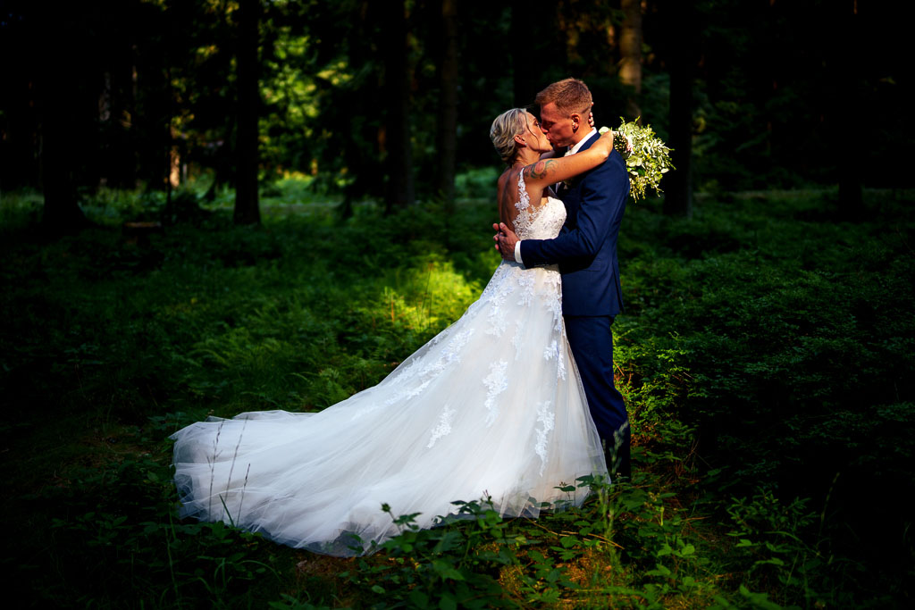 líbající se novomanželé v lese osvětlení sluncem